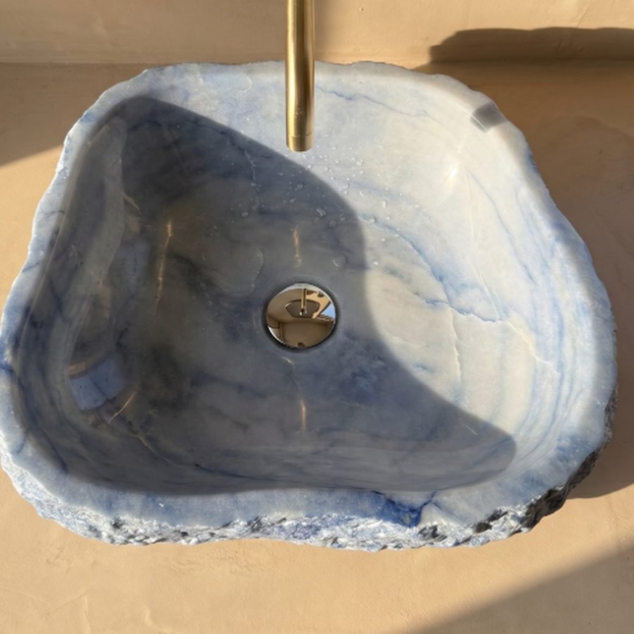 Cuba esculpida em quartzito azul com torneira dourada